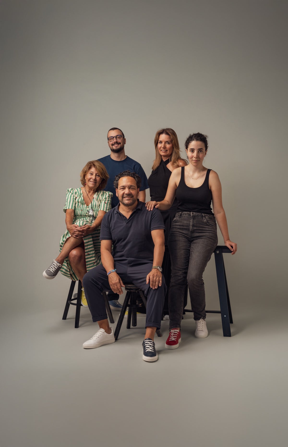 Five people from Vencer Autismo posing together, each in a mismatched pair of JAK sneakers