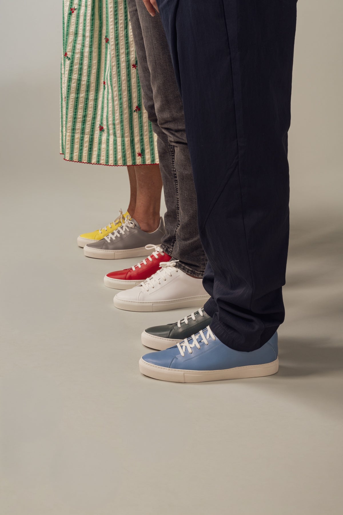 A line of feet in mismatched yellow, red, white, green and blue JAK sneakers