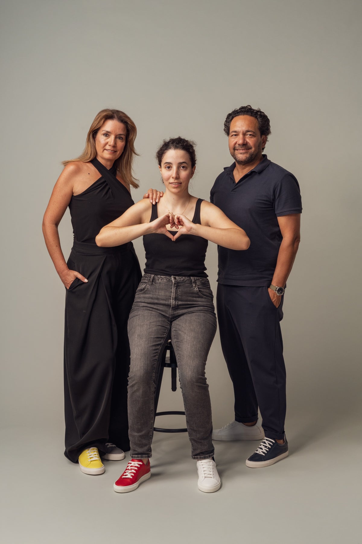 Three people from Vencer Autismo, the woman in the middle making a heart with her hands